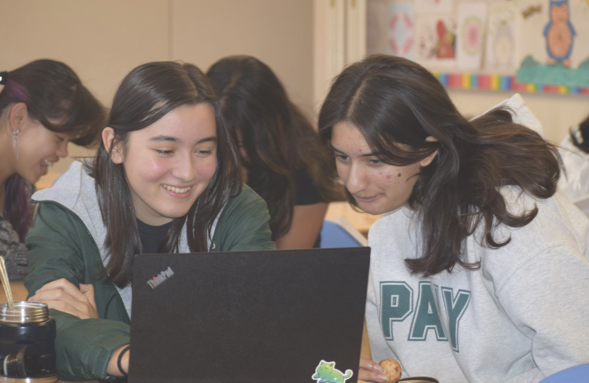 DRIVING CHANGE TOGETHER: Club leaders Manasvi Noronha (right) and Alice Jambon (left) discuss their oninions about the automative industry during their weekly club meeting during lunch in room 851. 